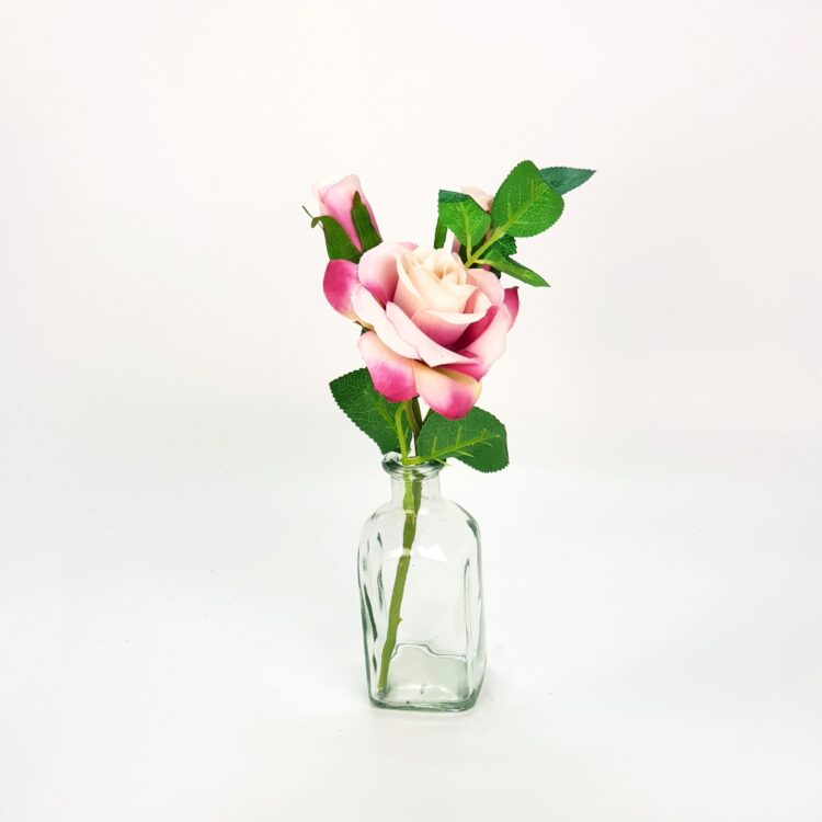 Glazen vaasje met roze roos